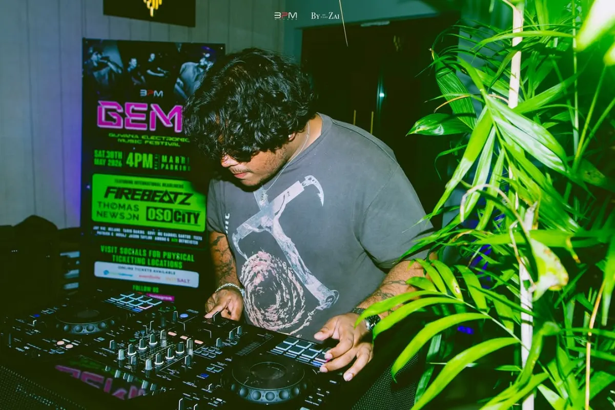 DJ on the decks at the GEMF 2026 launch event with the GEMF lineup flyer behind